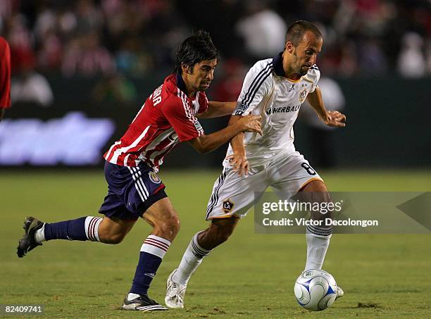 Peter Vagenas of the Los Angeles Galaxy looks to play the ball away from Paulo Nagamura of CD Chivas USA during their MLS match at the Home Depot...