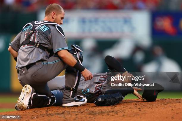 Chris Herrmann of the Arizona Diamondbacks comes to the aid of pitcher Robbie Ray of the Arizona Diamondbacks after he was hit in the head by a line...