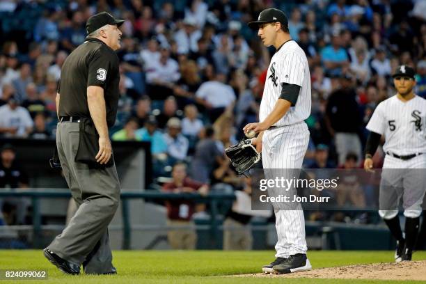 Home plate umpire Tim Welke talks with Derek Holland of the Chicago White Sox between pitches during the fourth inning at Guaranteed Rate Field on...