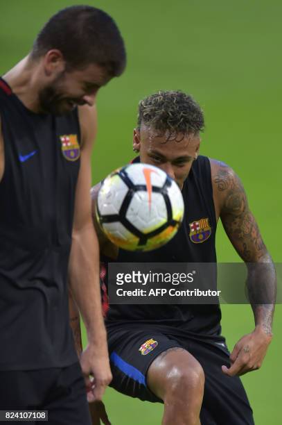 Barcelona players Neymar and Gerard Pique take part in a training session at Hard Rock Stadium in Miami, Florida, on July 28 one day before their...