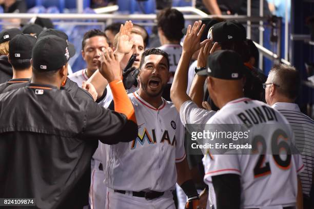 Mike Aviles of the Miami Marlins is congratulated by teammates after hitting a home run against the Cincinnati Reds at Marlins Park on July 28, 2017...