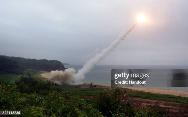 In this handout photo released by the South Korean Defense Ministry, U.S. Army Tactical Missile System firing a missile into the East Sea during a...