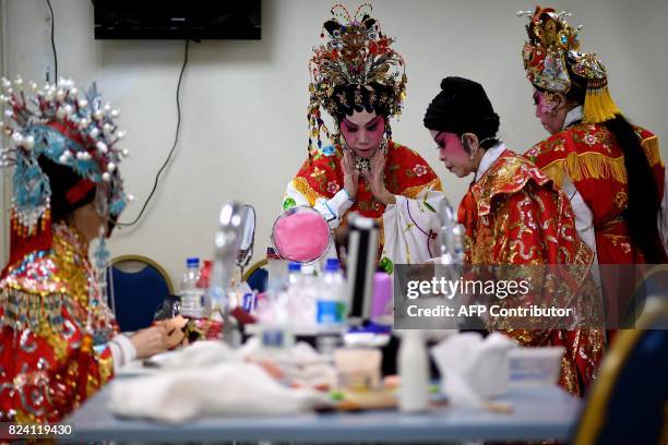 In this picture taken on July 28, 2017 ethnic Malaysian-Chinese Cantonese opera artists from the Sound of Tai Hei group prepare backstage before an...