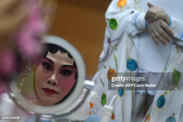 In this picture taken on July 28, 2017 an ethnic Malaysian-Chinese Cantonese opera actress from the Sound of Tai Hei group prepares backstage before...