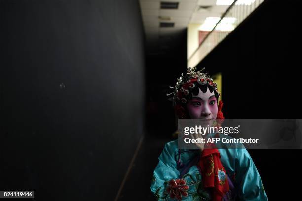 In this picture taken on July 28, 2017 a ten-year old Chinese Cantonese opera actressYujian Nuo from Beijing poses backstage before an opera...