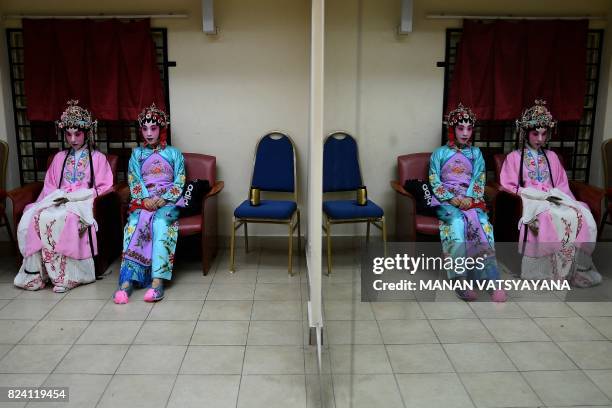 In this picture taken on July 28, 2017 Chinese cantonese opera actresses Mia Zhai and Yujian Nuo from Beijing wait backstage before an opera...