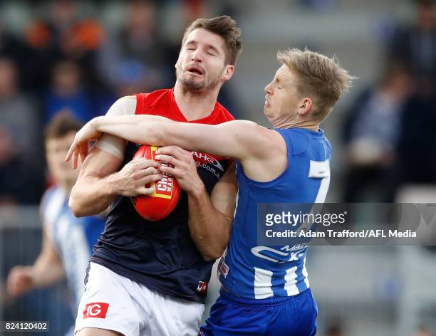 Jesse Hogan of the Demons is tackled by Jack Ziebell of the Kangaroos during the 2017 AFL round 19 match between the North Melbourne Kangaroos and...