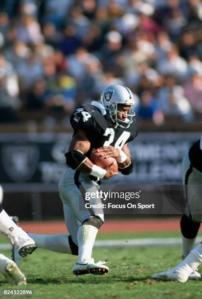 Bo Jackson of the Los Angeles Raiders carries the ball against the Kansas City Chiefs during an NFL Football game November 25, 1990 at the Los...