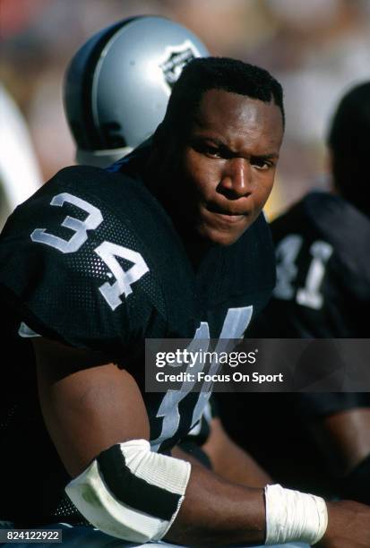 Bo Jackson of the Los Angeles Raiders looks on from the bench during an NFL Football game circa 1990 at the Los Angeles Memorial Coliseum in Los...