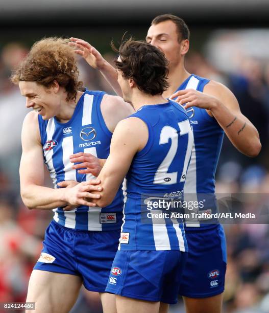 Ben Brown of the Kangaroos celebrates a goal with teammates Taylor Garner and Braydon Preuss during the 2017 AFL round 19 match between the North...