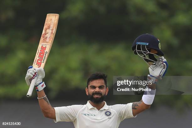 Indian cricket captain Virat Kohli celebrates after scoring 100 runs during the 4th Day's play in the 1st Test match between Sri Lanka and India at...