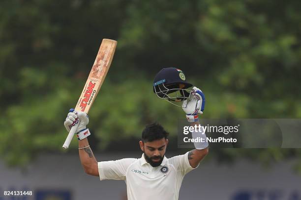 Indian cricket captain Virat Kohli celebrates after scoring 100 runs during the 4th Day's play in the 1st Test match between Sri Lanka and India at...