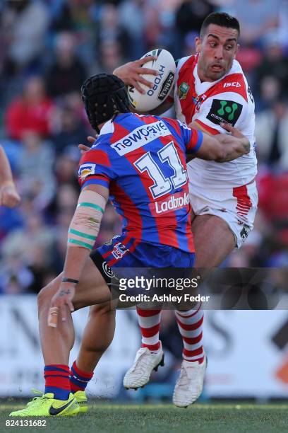 Paul Vaughan of the Dragos is tackled by the Knights defence during the round 21 NRL match between the Newcastle Knights and the St George Illawarra...