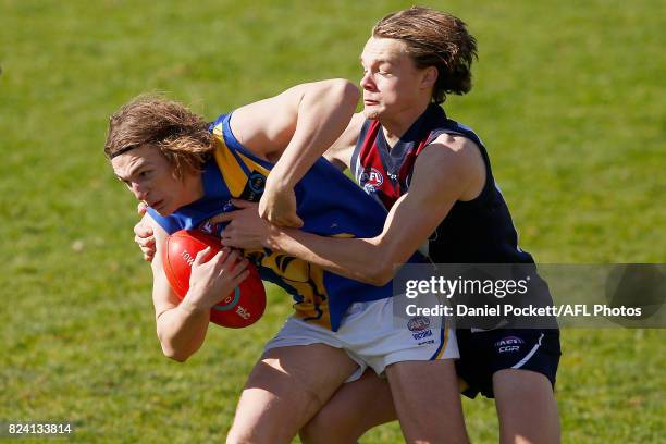 Joshua Mould of the Jets is tackled by Jacob Bakes of the Dragons during the round 14 TAC Cup match between Sandringham and the Western Jets at...