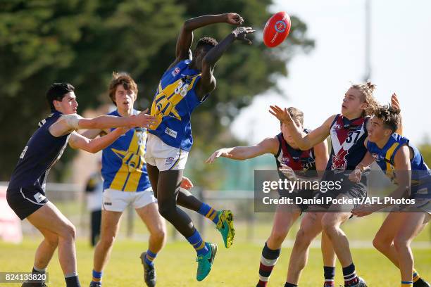 Buku Khamis of the Jets handpasses the ball under pressure during the round 14 TAC Cup match between Sandringham and the Western Jets at Frankston...