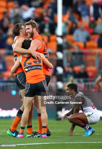 Dawson Simpson of the Giants celebrates with team mates Zac Williams and Rory Lobb after winning the round 19 AFL match between the Greater Western...