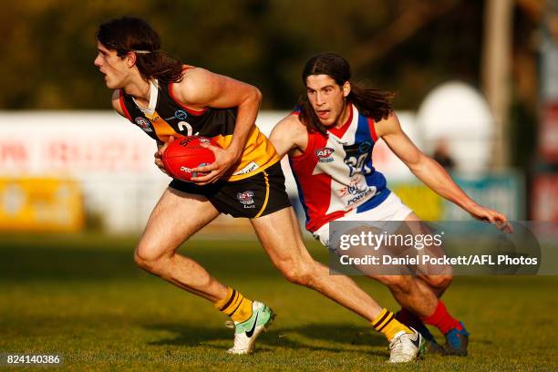 Hunter Clark of the Stingrays breaks away from Kim Drew of the Power during the round 14 TAC Cup match between Dandenong and Gippsland at Frankston...