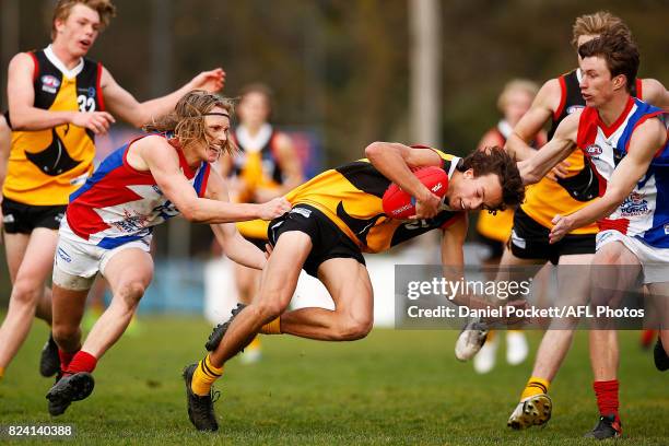 William Hamill of the Stingrays is tackled by Callum Porter of the Power during the round 14 TAC Cup match between Dandenong and Gippsland at...