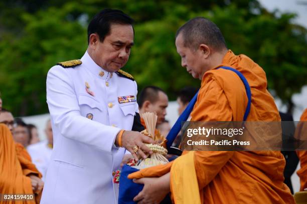 Thai Prime Minister Prayuth Chan-O-Cha gives alms to Buddhist monks to celebrate the birthday of Thai King Maha Vajiralongkorn in Bangkok, Thailand,...