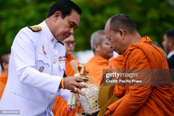 Thai Prime Minister Prayuth Chan-O-Cha gives alms to Buddhist monks to celebrate the birthday of Thai King Maha Vajiralongkorn in Bangkok, Thailand,...