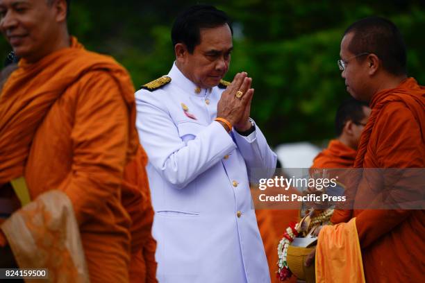 Thai Prime Minister Prayuth Chan-O-Cha gives alms to Buddhist monks to celebrate the birthday of Thai King Maha Vajiralongkorn in Bangkok, Thailand,...