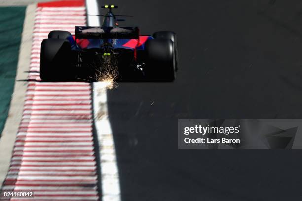 Sparks fly behind Carlos Sainz of Spain driving the Scuderia Toro Rosso STR12 on track during final practice for the Formula One Grand Prix of...