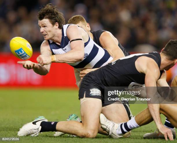 Patrick Dangerfield of the Cats handballs during the round 19 AFL match between the Carlton Blues and the Geelong Cats at Etihad Stadium on July 29,...