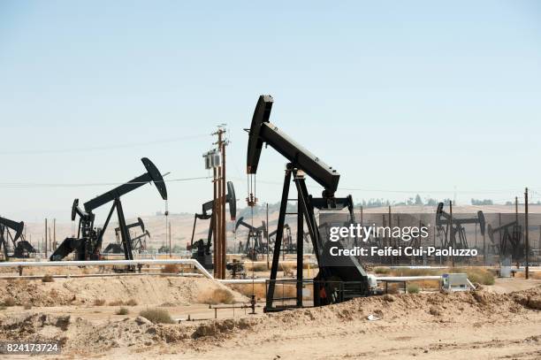 oil field and oil pump near bakersfield, california, usa - oil well stock-fotos und bilder