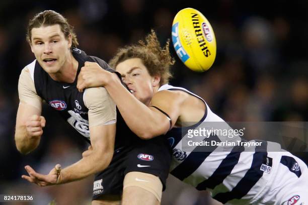 Wylie Buzza of the Cats tackles Bryce Gibbs of the Blues during the round 19 AFL match between the Carlton Blues and the Geelong Cats at Etihad...