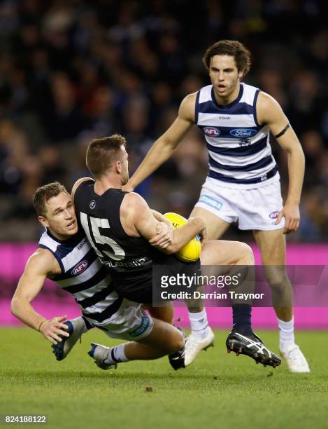 Joel Selwood of the Cats tackles Sam Docherty of the Blues during the round 19 AFL match between the Carlton Blues and the Geelong Cats at Etihad...