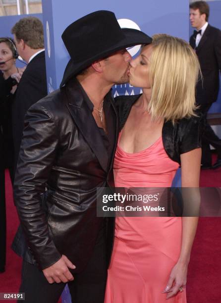 Country music singer Tim McGraw gives a loving kiss to wife Faith Hill February 21, 2001 outside the 43rd Annual Grammy Awards at the Staples Center...