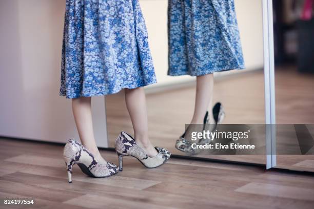 girl (4-5) playing in high heel shoes - linoleum stock-fotos und bilder