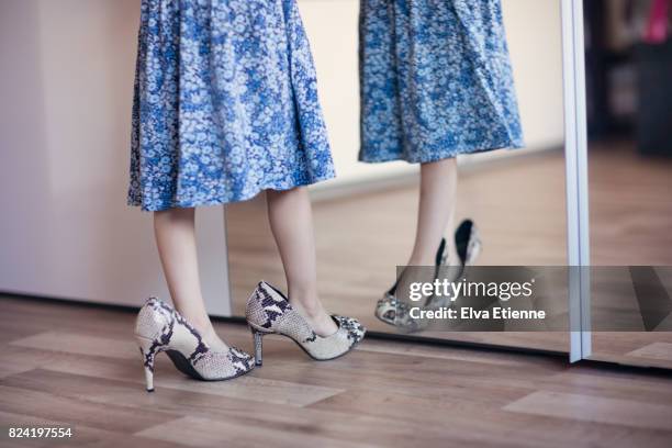 girl (4-5) playing in high heel shoes - lino stockfoto's en -beelden