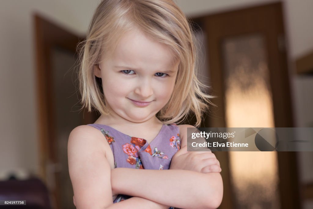Child (4-5) with arms folded and glaring, bossy facial expression