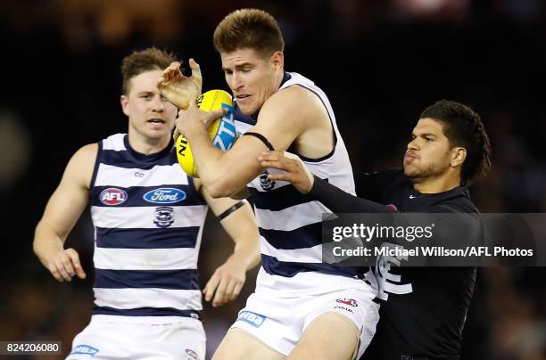 Zac Smith of the Cats is tackled by Sam Petrevski-Seton of the Blues during the 2017 AFL round 19 match between the Carlton Blues and the Geelong...