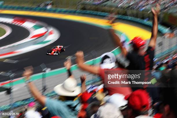 Fans cheer as Kimi Raikkonen of Finland driving the Scuderia Ferrari SF70H rounds the last corner during qualifying for the Formula One Grand Prix of...