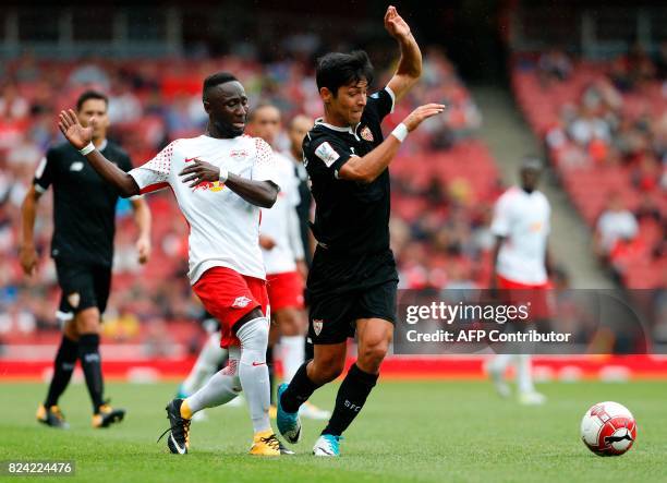 Leipzig's Swiss goalkeeper Yvon Mvogo vies with Sevilla's Argentinian midfielder Walter Montoya during the pre-season friendly football match between...