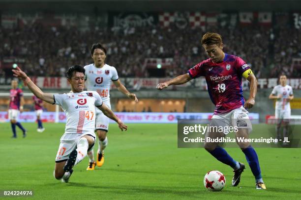 Kazuma Watanabe of Vissel Kobe is tackled by Yuzo Iwakami of Omiya Ardija during the J.League J1 match between Vissel Kobe and Omiya Ardija at Noevir...