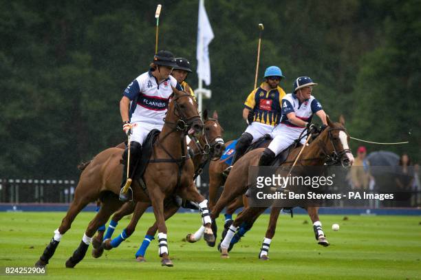 England, in white, and Commonwealth polo players during the Royal Salute Coronation Cup polo at Windsor Great Park in Surrey.