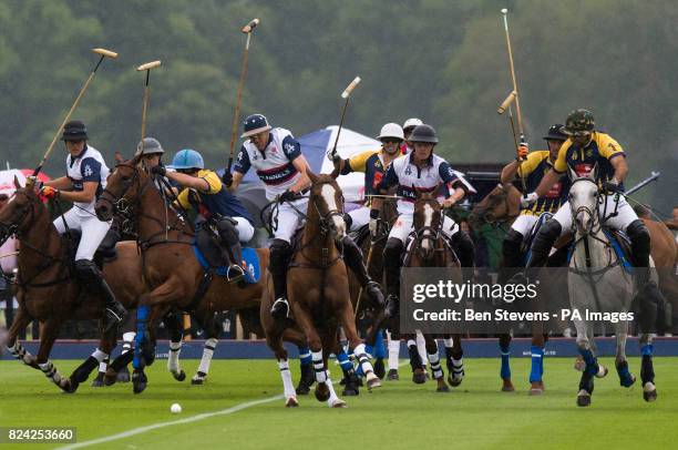 England, in white, and Commonwealth polo players during the Royal Salute Coronation Cup polo at Windsor Great Park in Surrey.