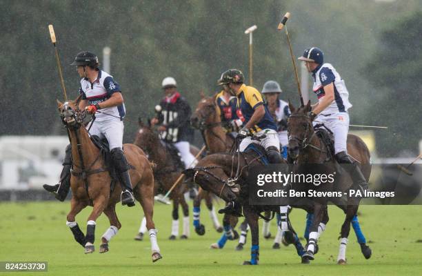 England, in white, and Commonwealth polo players during the Royal Salute Coronation Cup polo at Windsor Great Park in Surrey.