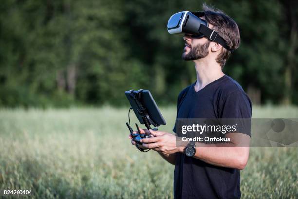 man vliegt een drone met virtual reality bril headset - radiografische afstandsbediening stockfoto's en -beelden