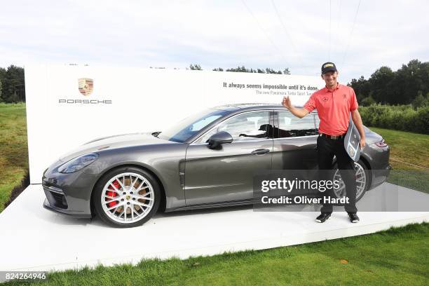 Marcel Siem of Germany receive his price Porsche Panamera Sport Turismo after making a hole in one on the 17th hole during the Green Eagle Golf...