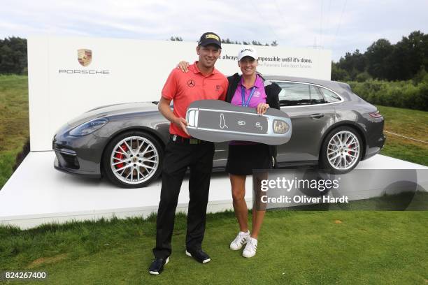 Marcel Siem of Germany and his wife poses with his price after making a hole in one on the 17th hole during the Green Eagle Golf Course on July 29,...