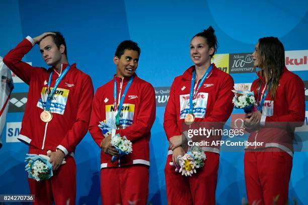 Canada's Yuri Kisil, Canada's Javier Acevedo, Canada's Chantal van Landeghem and Canada's Penny Oleksiak celebrate on the podium after the mixed...