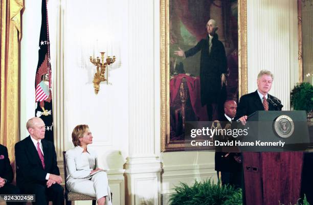 Former President Gerald Ford, and First Lady Hillary Clinton listen to President Bill Clinton speaking at the award ceremony in the East Room of the...