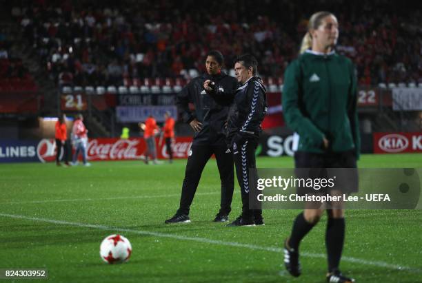 Steffi Jones, head coach of Germany and Nils Nielsen, head coach of Denmark talk shortly before the game was postponed due to heavy rain prior to the...