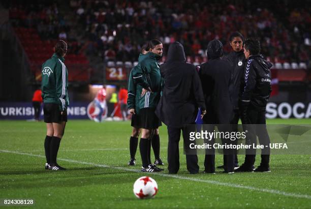 Steffi Jones , head coach of Germany and Nils Nielsen , head coach of Denmark talk with match officials shortly before the game was postponed due to...
