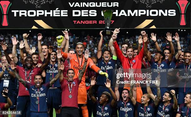 Paris Saint-Germain's Brazilian defender Thiago Silva holds the trophy as he celebrates with teammates after winning the French Trophy of Champions...