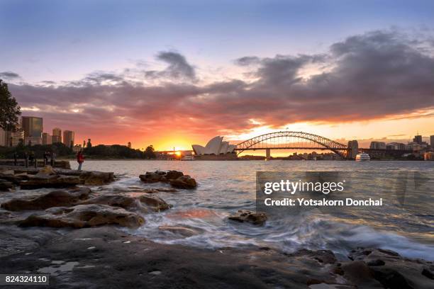 a sunset over harbour bridge and sydney opera house from mrs. macquarie's point, australia - sydney harbour bridge opera house stock pictures, royalty-free photos & images